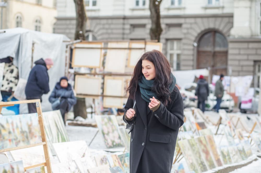 Artist browsing paintings at an outdoor art fair